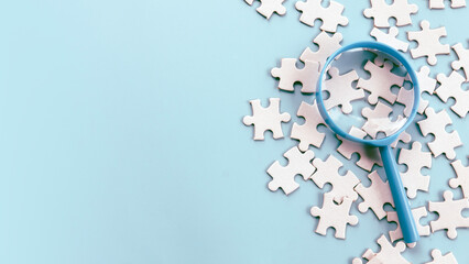 Magnifying Glass Over Jigsaw Puzzle Pieces for Detailed Inspection