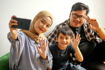 Attractive Asian Family, Mother, Son And Father Doing Selfie Together Using Smartphone