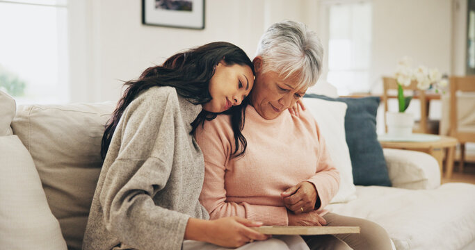 Women, senior mother and sad with photo frame, hug and empathy for grief, memory and love in lounge. Family, people and embrace with support, trust and comfort in house for depression in retirement