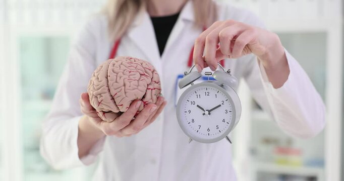 Alarm clock and brain anatomy in the hands of a neurologist doctor and treatment of insomnia
