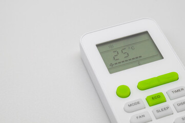 Remote control air conditioning. Turn on economical mode of operation air conditioner. Conserving electrical energy during an energy crisis and saving money to pay for energy costs. Selective focus
