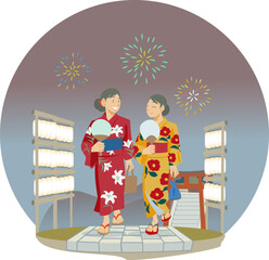 夜の石畳の道を歩く浴衣を着た女性たち