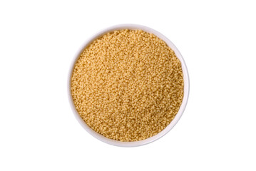 Wheat porridge couscous grains on a dark concrete background