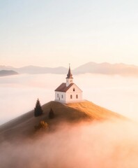 Naklejka premium Serene Hilltop Church Surrounded by Mist at Sunrise