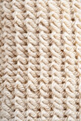 Close-Up Texture of Beige Knitted Fabric with Intricate Patterns and Soft Woolen Threads for Background or Textile Design