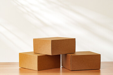Stacked Cardboard Boxes On Wooden Surface In Sunlight
