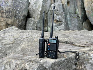 Walkie talkies on the rocky background. Concept of wireless communications. Off grid communication methods. Communications with team during a search and rescue operation.