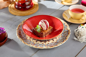 Decadent Brownie with a Scoop of Ice Cream on a Red Plate