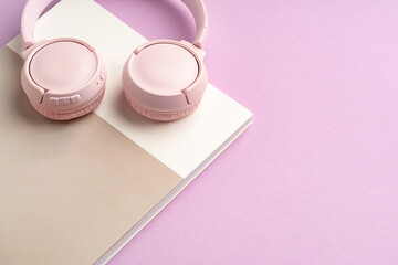 Stylish pink headphones and sunglasses on a pastel background