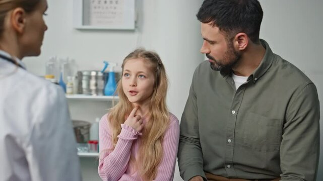 Sick girl talking pediatrician in clinic closeup. Ill kid describing symptoms