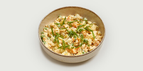 A classic Ukranian Olivier salad is presented in a beige bowl against a clean white background.