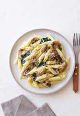 Penne pasta with mushrooms, spinach and cheese. Healthy food. Vegetarian food.