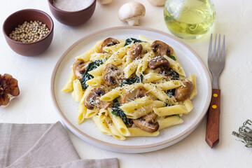 Penne pasta with mushrooms, spinach and cheese. Healthy food. Vegetarian food.