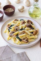 Penne pasta with mushrooms, spinach and cheese. Healthy food. Vegetarian food.