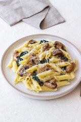 Penne pasta with mushrooms, spinach and cheese. Healthy food. Vegetarian food.