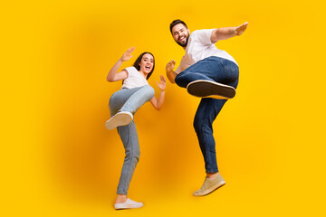 Full length photo of lovely young guy girl kick legs have fun fight dressed stylish white garment...