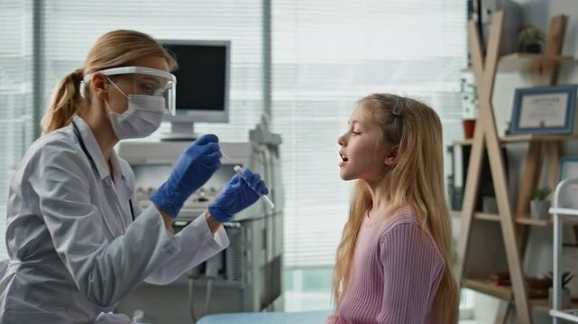 Doctor taking saliva sample in examination room closeup. Child health checkup