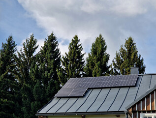 self-sufficient cottage house in the forest thanks to solar panels covering the roof in the...