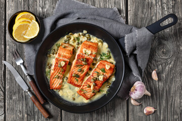 salmon piccata with lemon caper sauce in a pan