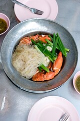 Steamed mud crab with glass noodles, green onions and chives served with nam jim jaew (seafood dipping sauce) at Somsak Pu Ob (Charoen Rat) a street food cart in Khlong San - Bangkok, Thailand