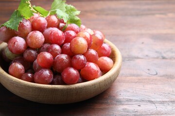Fresh ripe grapes on wooden table, closeup. Space for text