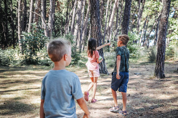 Three kids playing in the forest