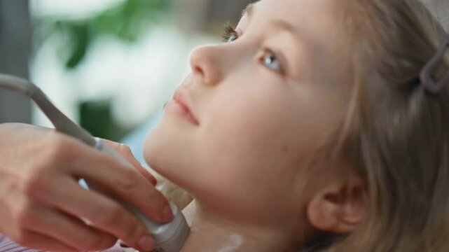 Hand performing ultrasound examination of girl. Closeup pediatric patient visit