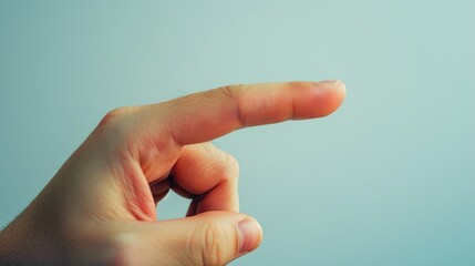 A close-up of a hand pointing to the right, isolated on a light blue background.
