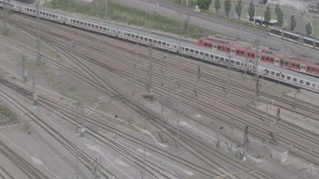 Red trains on multiple railway tracks in a train yard, aerial view