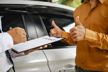 In a showroom, people engage in buying or leasing cars, working with salespeople to finalize contractsDiscussions involve choices agreements financingThe process includes paperwork explaining terms