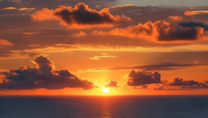 Stunning sunset painting the ocean in vibrant orange hues with wispy clouds adorning the sky