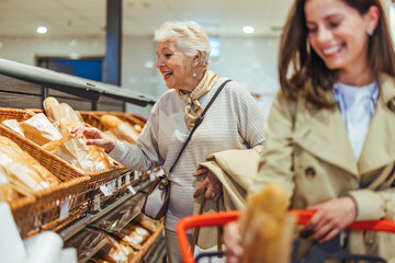 Happy Senior Woman Shopping for Bread with Daughter in Grocery Store