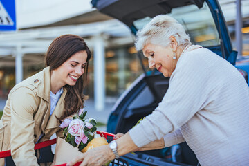 Smiling Women Loading Groceries into Car Trunk at Supermarket © Dragana Gordic