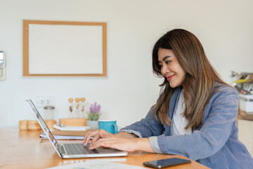 Young Female Freelancer Working from Home on Laptop in Modern Cozy Home Office Setting