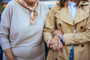 Elderly Woman and Younger Companion Holding Hands in Comfort