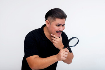 A suspicious middle-aged man inspecting something with a magnifying glass. Pondering the veracity...