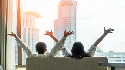 Relaxing couple lifestyle celebrating happy resting in luxury city condominium, urban condo, home apartment, or business hotel tower for family life-work balance and marriage living quality concept
