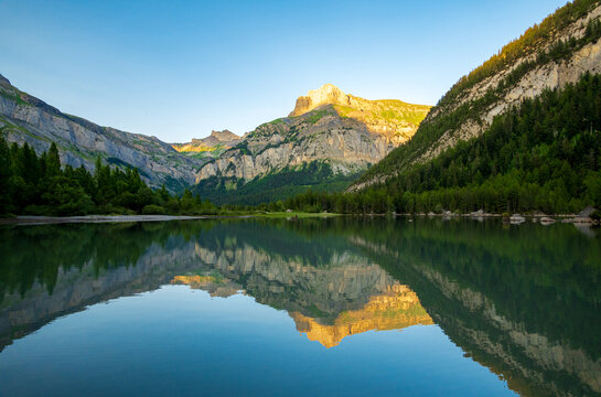 Serene lake reflection with Alpine mountains at sunrise