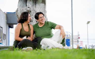 Joyful LGBTQ couple laughing with puppy at park