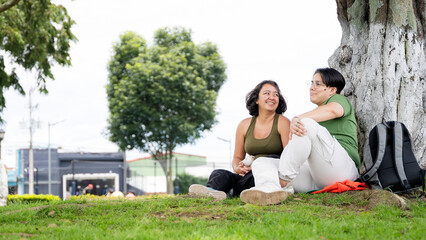 LGBTQ couple relaxing and laughing in a park