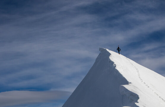Climber reaching the summit in Swiss Alps