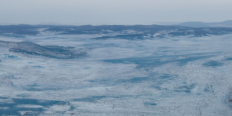 Obraz premium Expansive frozen landscape overlooking icy terrain and snow-capped mountains