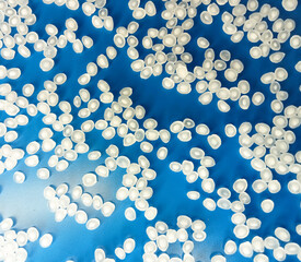 natural polymer granules, virgin raw material, virgin plastic resin, isolated on blue background,...
