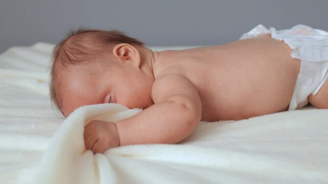 Cute baby engaging in tummy time on cozy blanket learning to crawl and move around trying lifting head discovering world through playful exploration and charming activities in infancy