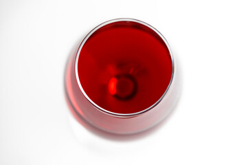 Single glass of red cabernet pino merlot malbec wine and deep red glow isolated on white background