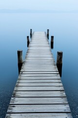 Fototapeta premium A quaint fishing dock with old wooden planks stretching out over calm water