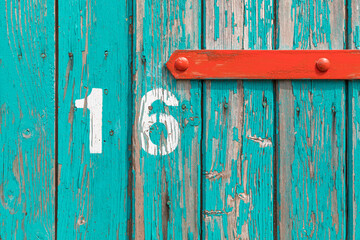 Weathered wooden Turquoise door with number 16 background