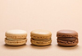 Closeup of macarons pastry with vanilla, coffee and chocolate flavor on brown background