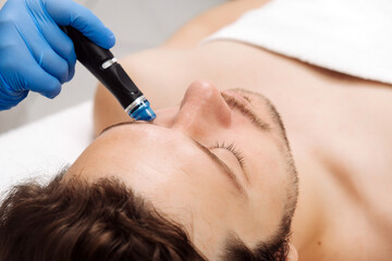 A man undergoes a hydrofacial treatment at a beauty clinic. This advanced procedure rejuvenates and...
