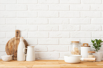 Food and kitchen accessories on wood table over white brick wall background